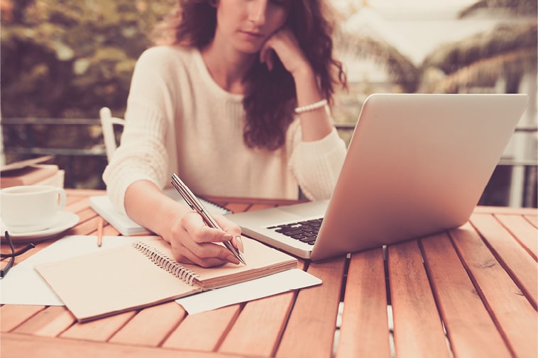 woman working on laptop, looking concerned, trying to figure out how to gain website success.